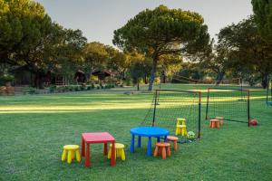 - une aire de jeux avec des tables et des chaises colorées dans un parc dans l'établissement Aldeamento Turístico da Companhia das Lezírias, à Samora Correia
