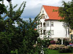 ein großes weißes Gebäude mit rotem Dach in der Unterkunft Villa Werndl in Millstatt