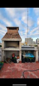 un horno de ladrillo con ollas y cubos en el techo en Duplex Moreno en Santiago del Estero