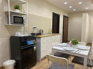 a kitchen with a table and a black refrigerator at Chelay studios Nasr city in Cairo