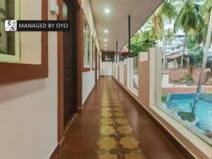 pasillo de una casa con piscina y suelo enfermo en OYO Arpora Baga, en Baga