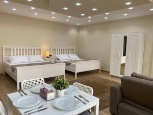 a bedroom with two beds and a table and chairs at Chelay studios Nasr city in Cairo