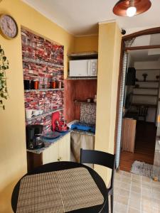 eine kleine Küche mit einem Tisch und einer Uhr an der Wand in der Unterkunft My Home 2 quartos em Cobertura ao lado da praia in Rio de Janeiro