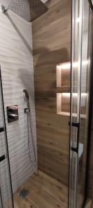 a bathroom with a shower with a wooden wall at Apartament Słoneczny in Tarnów