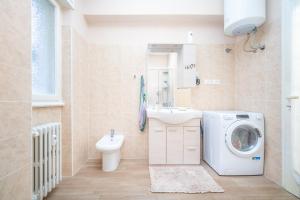 uma casa de banho com uma máquina de lavar roupa e um lavatório em Orlando Home em Trieste