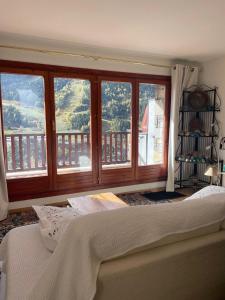 a bedroom with large windows and a bed in front thereof at Chez Maurice avec une belle vue in El Tarter