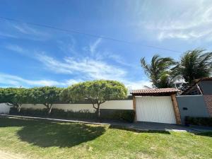 una casa con una valla y árboles en un patio en Casa de Praia em Morro Branco-CE en Beberibe