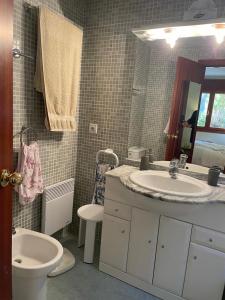 uma casa de banho com um lavatório, um WC e um espelho. em Chez Maurice avec une belle vue em El Tarter