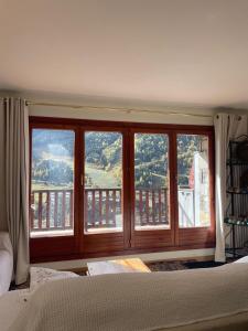 um quarto com uma grande janela com vista em Chez Maurice avec une belle vue em El Tarter