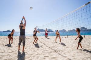 een groep mensen die volleyballen op het strand bij Riu Santa Fe - All Inclusive in Cabo San Lucas