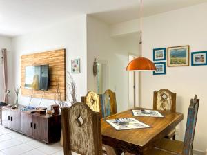 uma sala de jantar com uma mesa de madeira e cadeiras em Apto a 350m da Praia de Maitinga em Bertioga SP em Bertioga