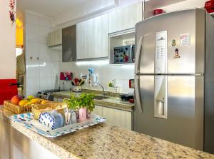 a kitchen with a stainless steel refrigerator and a counter at Apto a 350m da Praia de Maitinga em Bertioga SP in Bertioga