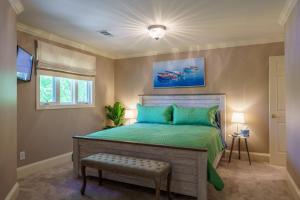 ein Schlafzimmer mit einem Bett mit einer grünen Bettdecke in der Unterkunft Lakeside Paradise - Luxury by the lake in Afton