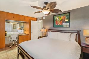 a bedroom with a bed with a ceiling fan at Kihei Beach 606 - Direct Ocean Front, Central AC! in Kihei +99 photos