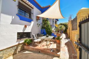 een patio met een tafel en stoelen voor een gebouw bij Vega’s Love in Málaga