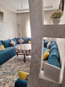 - un salon avec un canapé bleu et un ordinateur portable dans l'établissement Agadir Tranquility : Cozy Pad, à Agadir