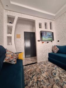 - un salon avec un canapé bleu et une porte noire dans l'établissement Agadir Tranquility : Cozy Pad, à Agadir