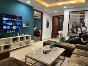 een woonkamer met een bank en een tafel bij 2BR Gold Crest Luxurious Residency Apartment BY AirHomes DHA Lahore in Lahore