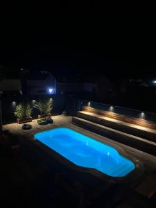 uma piscina à noite com luzes acesas em Compay Hostel Punta del Diablo em Punta Del Diablo