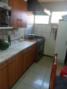 una cucina con piano cottura e frigorifero di Habitación casa familia a La Serena