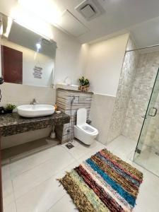 ein Bad mit einem Waschbecken, einem WC und einer Dusche in der Unterkunft 2BR Gold Crest Luxurious Residency Apartment BY AirHomes DHA Lahore in Lahore