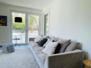 - un salon avec un canapé et des oreillers dans l'établissement Luxury Green Flat in Center with Parking & Terrace, à Luxembourg