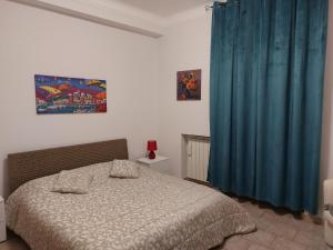 1 dormitorio con cama y cortina azul en Marina Apartments, en Taranto