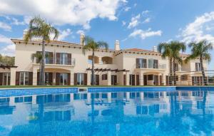 阿爾布費拉的住宿－Villa Cascata, 3 bedroom, Pool, close to Olhos de Agua，一座带游泳池和棕榈树的建筑