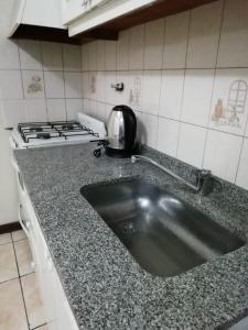 a kitchen counter with a sink and a stove at Apex Apart in Mendoza