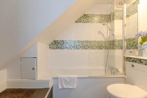 a bathroom with a toilet and a bath tub at Radiant and Roomy 2BD Flat - Fulham! in London