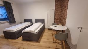 um quarto com duas camas e uma mesa em Kaiserslautern Apartments em Kaiserslautern