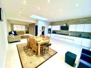 a kitchen and living room with a wooden table and chairs at Luxury 5 bedroom home with private car park in London in Hendon