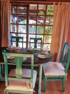 stół i krzesła ze stołem i oknem w obiekcie Alojamientos La Casita del Centro w mieście Panguipulli