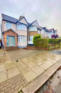 a large house with a driveway in front of it at Luxury 5 bedroom home with private car park in London in Hendon