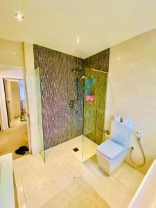 a bathroom with a toilet and a glass shower at Luxury 5 bedroom home with private car park in London in Hendon