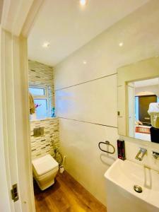 a bathroom with a white toilet and a sink at Luxury 5 bedroom home with private car park in London in Hendon