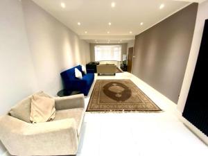 a living room with a couch and a chair at Luxury 5 bedroom home with private car park in London in Hendon