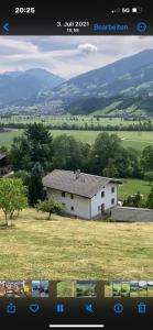 ein Bild eines weißen Hauses auf einem Feld in der Unterkunft Landhaus Johannes in Hart im Zillertal