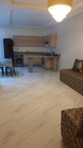 ein Wohnzimmer mit einem Sofa und einem Tisch in der Unterkunft Appartement Calme avec Piscine Mohemmadia Zenata in Aïn Harrouda