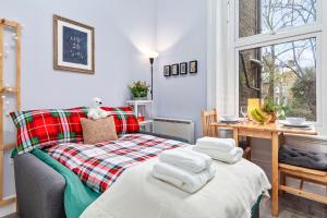 - une chambre avec un lit et des serviettes dans l'établissement Olympia Kensington Stay Studio, à Londres