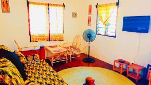un soggiorno con divano e tavolo con ventilatore di Mkayamba House a Malindi