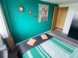 1 dormitorio con 1 cama con pared azul en Manchester’s view, en Mánchester