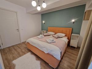 a bedroom with a bed with two towels on it at Golden Airport Residence in Otopeni