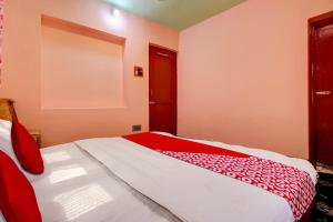 Schlafzimmer mit einem Bett mit einer roten und weißen Decke in der Unterkunft OYO Flagship Wooden Cave By M2 in Srinagar