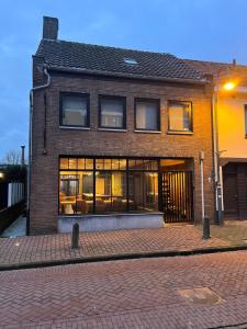 a brick house with windows on a brick street at La Petite Fleur in Baarle-Nassau