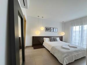 a bedroom with a large bed and two pendant lights at Casa Jimena in Ávila