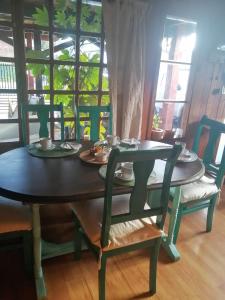 una mesa y sillas con platos y tazas. en Alojamientos La Casita del Centro, en Panguipulli