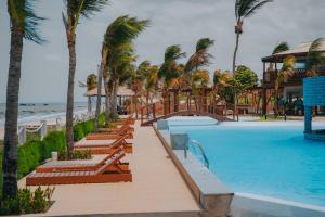 - une piscine bordée de palmiers et une plage dans l'établissement Oiti Beach Resort Tutoia, à Tutóia