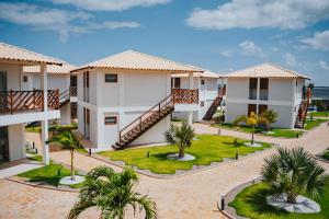 un complejo de apartamentos con un patio con palmeras en Oiti Beach Resort Tutoia, en Tutóia