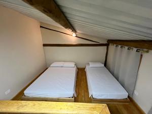 two beds in a small room in a tent at Pousada Dona Carmem Ubatuba in Ubatuba